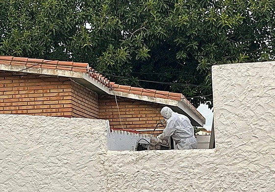 A worker removes asbestos from the roof of a school.