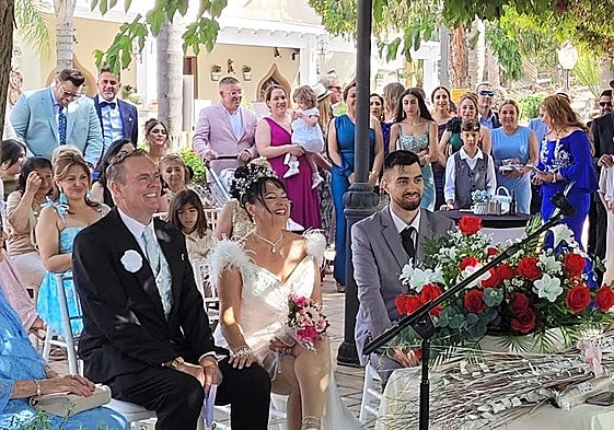 The happy couple with family and friends during the ceremony.