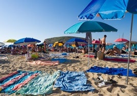 Beachgoers in Cala de Conta in Ibiza