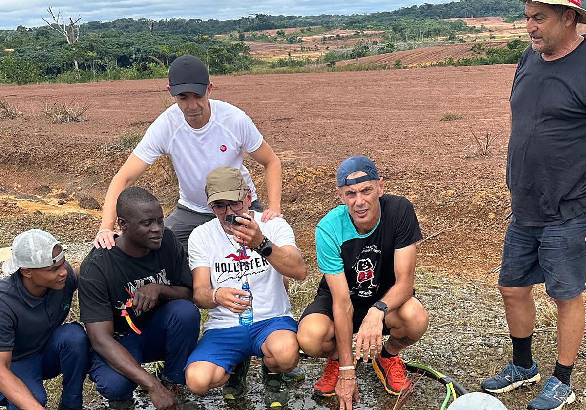 Francisco Martín, with a bottle of water, together with several members of the NGO and residents of Mebere.