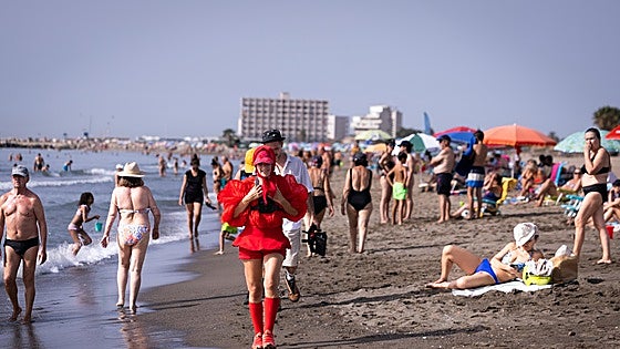 Who is the woman in red crossing the beaches of Malaga?