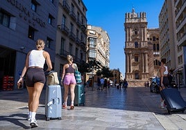 Tourists make their way through the city centre to their accommodation.