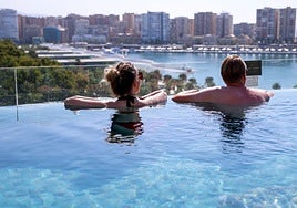 Tourists enjoy themselves in the swimming pool of a hotel in Malaga city.