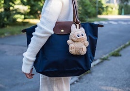 Teenage girl with her Longchamp bag attached to a Labubu keychain.