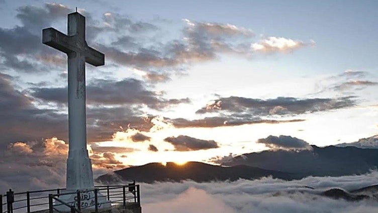 The castle in Spain's Andalucía region with a giant cross soaring above the clouds