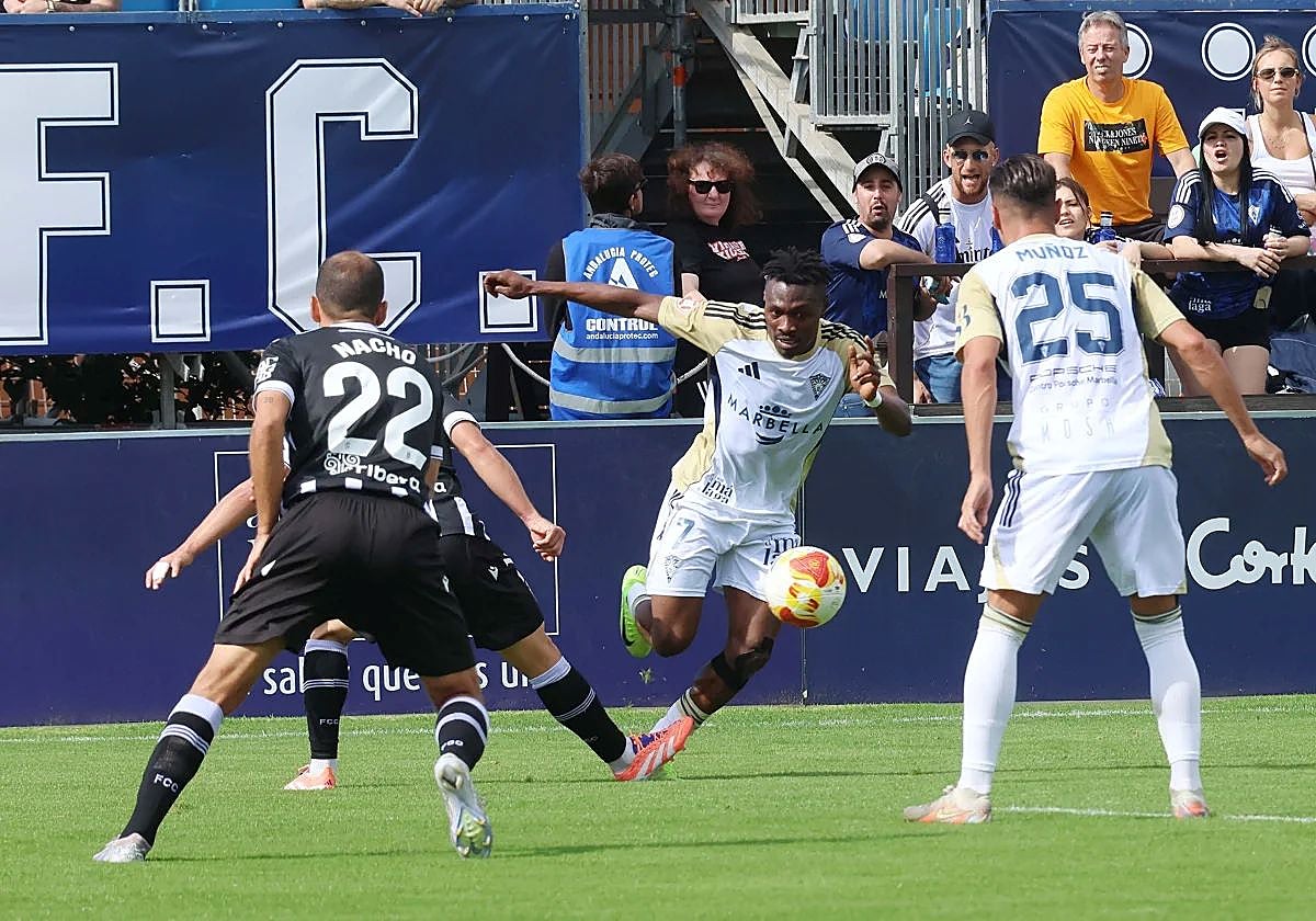 Marbella's Tahiru attempts to progress with the ball.