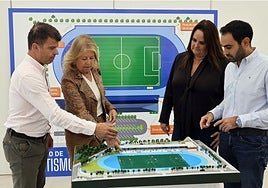 The mayor and councillors look at the model of the stadium.
