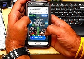A man uses his mobile phone to access the website of an online bookmaker.