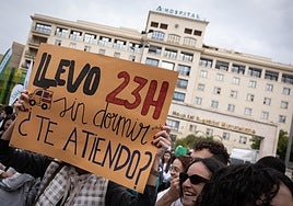 A doctor holds up a poster denouncing long on-call shifts during the rally on Thursday.