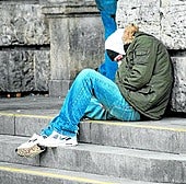 A homeless person takes shelter from the cold in the street.