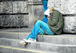 A homeless person takes shelter from the cold in the street.