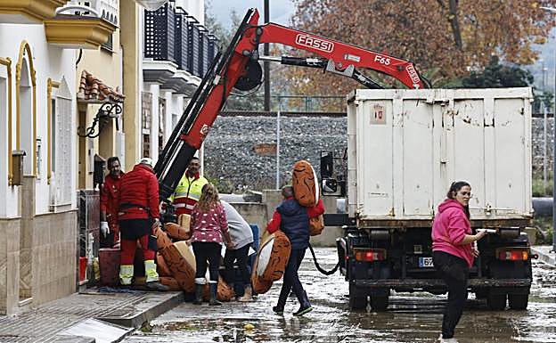 Recovery teams and families cleaning up and disposing of ruined belongings.