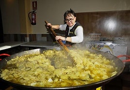 A resident of Cozvíjar preparing 'patatas a lo pobre' at last year's Feria de la Matanza in Cozvíjar.