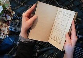 A person wearing tartan reads a book of poems by Robert Burns .