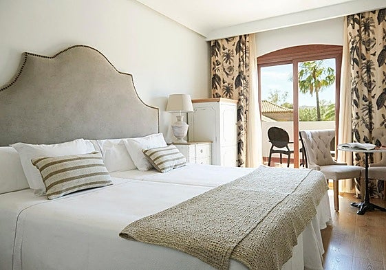 A bedrrom at La Viñuela hotel of which the headboard, bedside table and chairs are for sale.