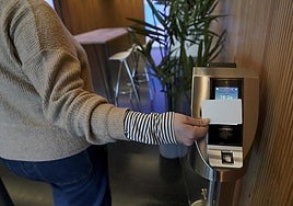 A worker marking her pass at her company's access control point.