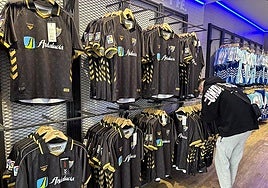 A fan looks at the new retro shirt at the club shop at La Rosaleda stadium.