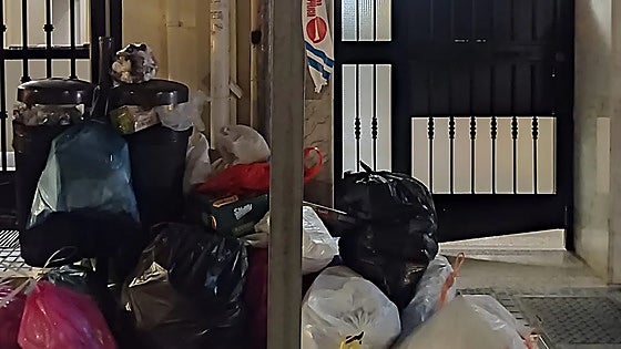 Elderly Malaga resident cannot get home due to garbage bags pile