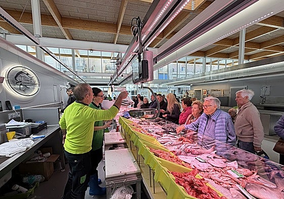 A busy fish stall in a Spanish food market.