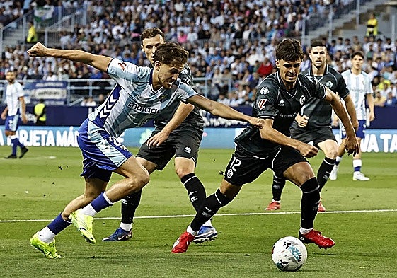 Malaga's Adrián Niño tries to force an opening on Saturday.