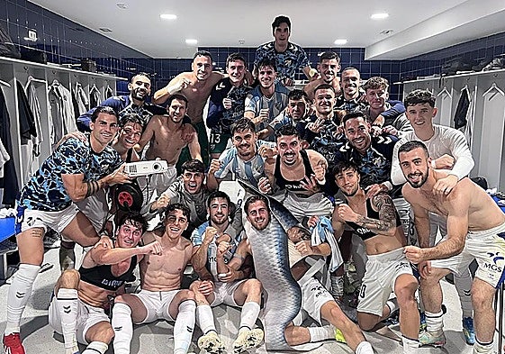 The Malaga players celebrate a crucial win in the changing room following the game.