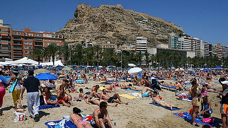 Tourists enjoying a beach day in Alicante.