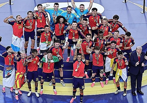 Spain captain Rodri lifts the World Cup trophy, surrounded by his teammates.