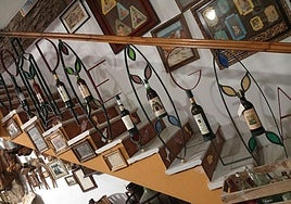 Stairs in Casa Museo Axarquía in El Valdés decorated with bottles of wine from the Axarquía.