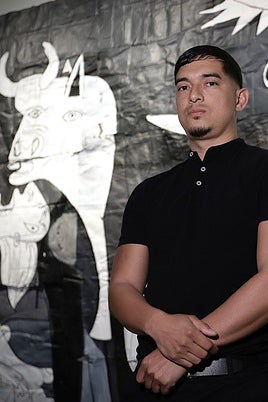Anaya, standing in front of his version of Guernica.