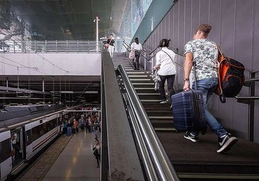 Passengers walking up the stairs at the Renfe station at Malaga Airport.