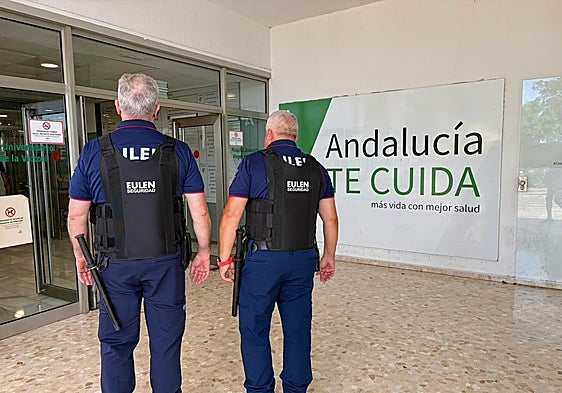 Two security guards at the main entrance to Malaga's Hospital Clínico.