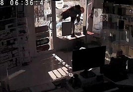 The thief breaks into the shop by smashing the window.
