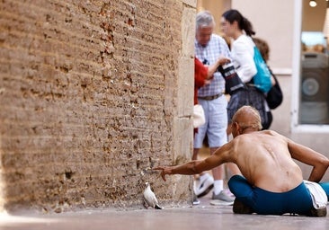 A man sitting on the ground on Calle Francisco de Rioja in Malaga.