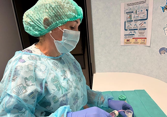 A healthcare professional is handling breast milk.