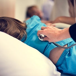 A paediatrician is treating a child.