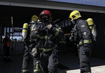 Firefighters rescue a person trapped in an overturned car following an accident in Churriana