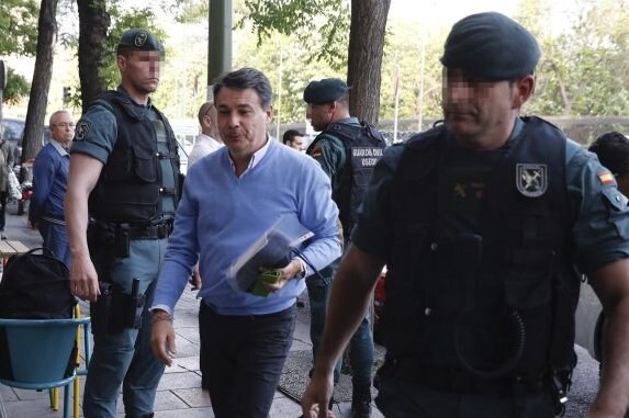 Ignacio González, escorted by Guardia Civil agents, arrives at his office on Wednesday.