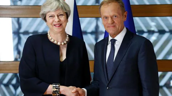Theresa May and Donald Tusk shake hands ahead of the summit in Brussels.