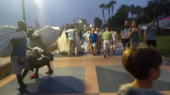 Hawkers pack up their wares on the seafront in Torremolinos.