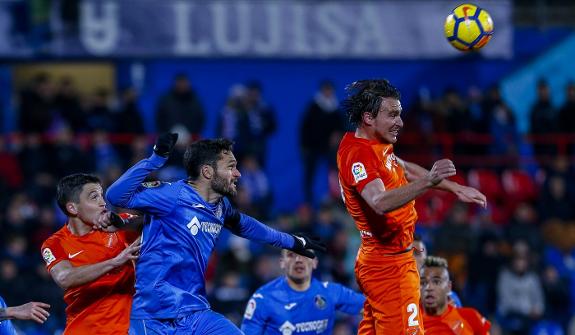 Jorge Molina challenges for the ball with Ignasi Miquel.