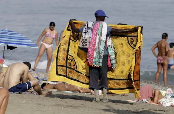 A hawker sells his goods on the La Malagueta beach.  