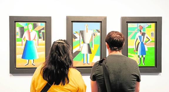 Visitors admire Malevich’s Peasants at the exhibition in the Russian museum in the Tabacalera building in Malaga.
