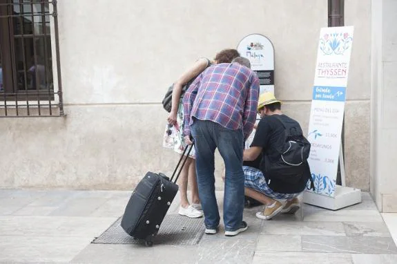 Tourists examine a map in Malaga city centre.