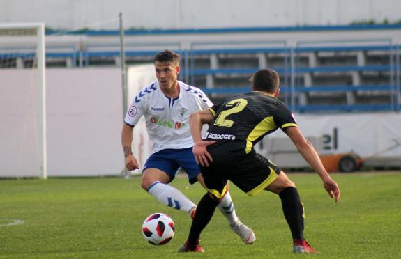 Juanma controls the ball under pressure from Marín.