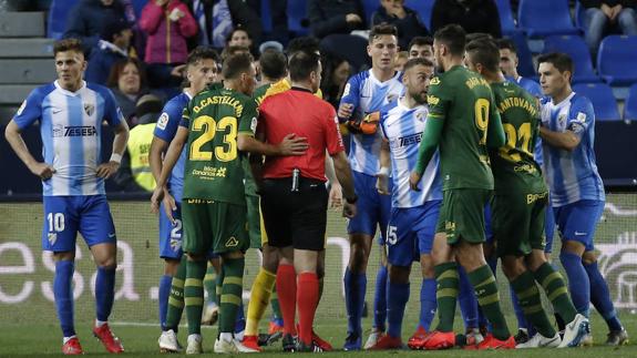 The players surround the referee after he showed red to Keidi Bare for his second yellow card.