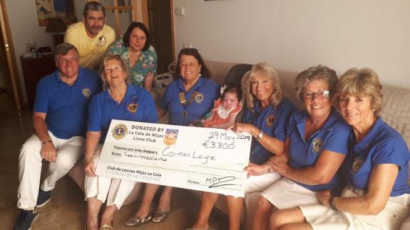 Lions members present the family with a cheque to help fund Carmen's care.