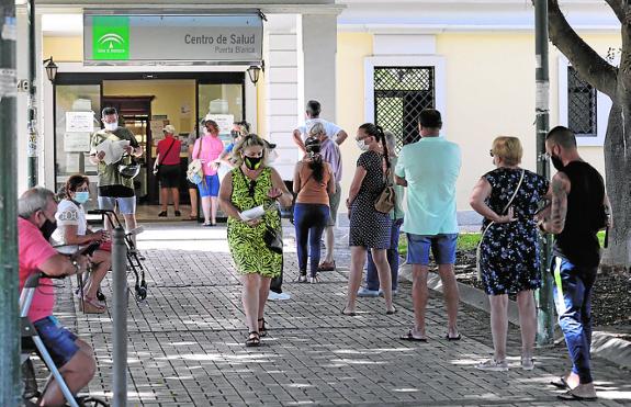 People wait patiently outside in the hope of getting an appointment.