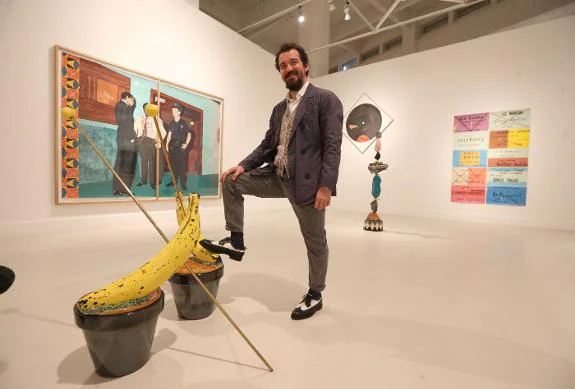 Miki Leal, next to one of his ceramic creations, surrounded by paintings influenced by jazz. 