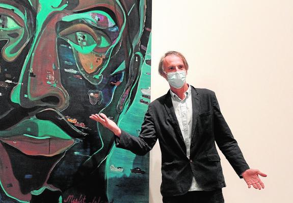 Jules de Balincourt poses with his self-portrait, where his face is in reality an island. 