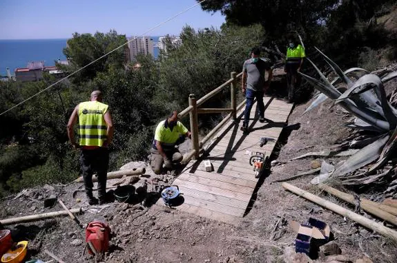Workers install the six-metre wooden bridge. 